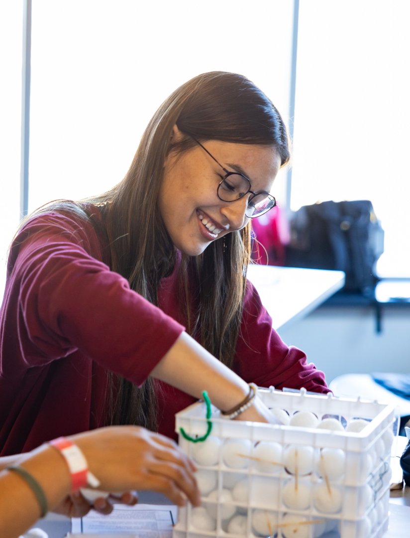 Student with her hand in a box of emulated particles