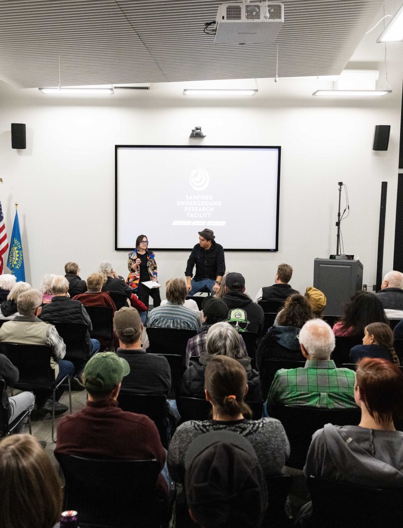 Two people presenting to a group of adults